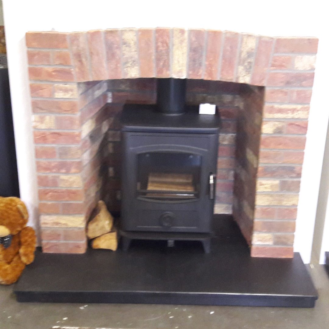 Screenshot_20200122-111506_Gallery Multi fuel stove in brick inset with brick surround and black hearth