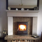 Multi fuel stove in marble inset and marble mantle with log storage