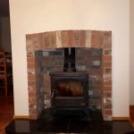 Multi fuel stove in brick inset with brick surround