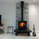 Modern Multi fuel stove with slate backing and log storage